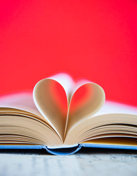 istock Heart from a book page on red background 1628918235