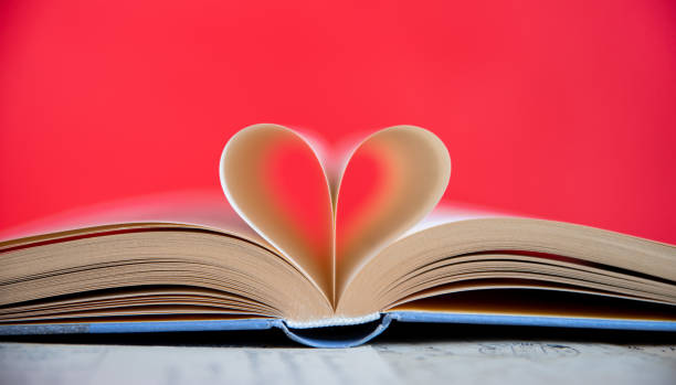 istock Heart from a book page on red background 1628918263
