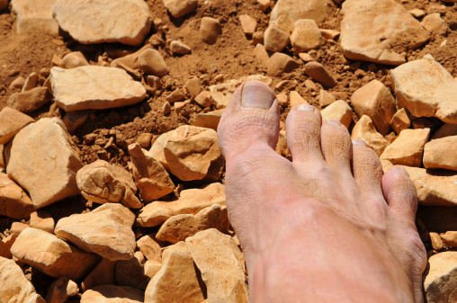Close up view of a dry and dusty foot after a long walk in the desert