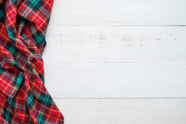 istock Red green plaid napkin on white wooden table background. 1628954724