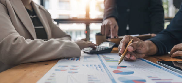 istock Business People Meeting using laptop computer,calculator,notebook,stock market chart paper for analysis Plans to improve quality next month. Conference Discussion Corporate Concept. 1628958608