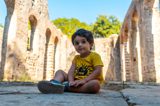 A boy playing in Great Basilica in the archaeological ruins of Butrint or Butrinto National Park in Albania