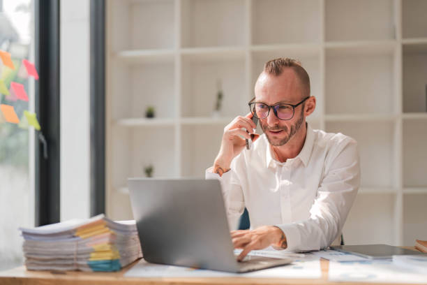 istock Businessman using laptop computer in office. Happy middle aged man, entrepreneur, small business owner working online. 1628961831