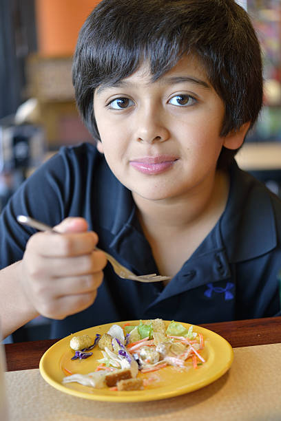 istock Boy eating a salad during school lunch 162897209
