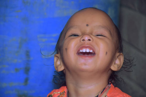 cute baby girl making smiley face, with blue background