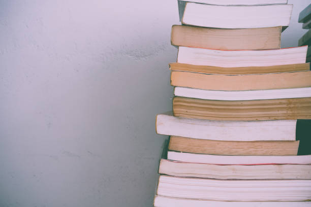 istock Stack of many old books on shelf in book store or library room with white wall background. 1628979702