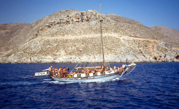 Kos Island, Greece - Aug 1990: a classic wooden gulet, typical of the Aegean Sea, sails along the coast of Kos carrying tourists on excursions.