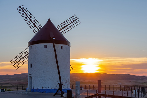 Mills in the town of Consuegra.  Landscape of several white windmills and brown windmills on the hill.  ancient architecture.  Farm houses.