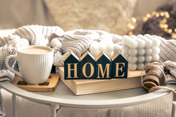 istock Cozy composition with candles, coffee and decorative word home. 1629005555