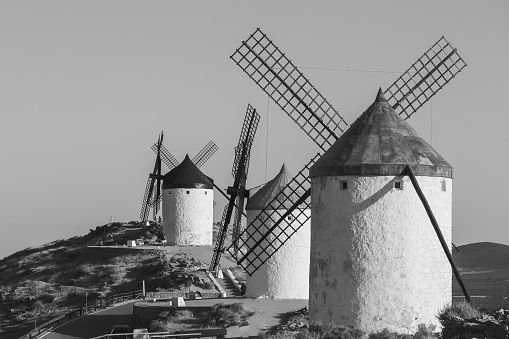 Mills in the town of Consuegra.  Landscape of several white windmills and brown windmills on the hill.  ancient architecture.  Farm houses.