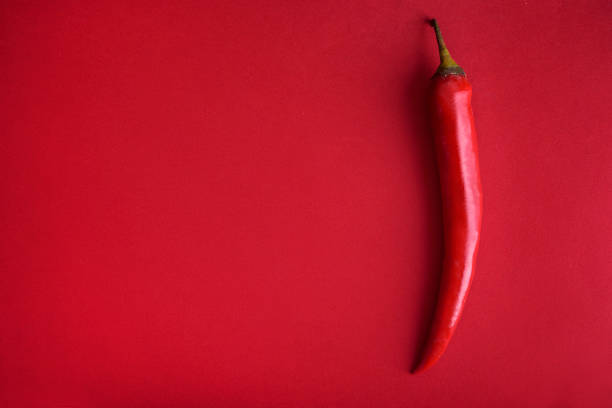 istock Food background flat lay. Red hot chili pepper on red background from above. 1629007760
