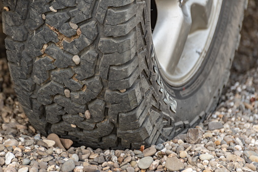 Off-road mud tires on the shore with pebbles