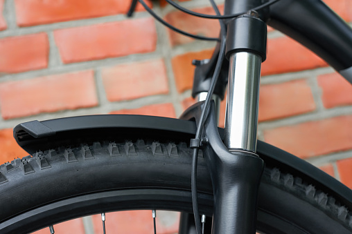 Close-up of the suspension fork of the front wheel of a bicycle. Outdoors.