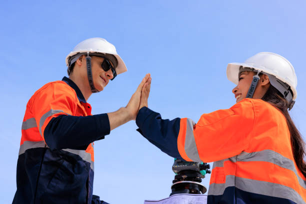istock engineer and surveyor engineers high five after work at road construction site, angle shot 1629061028