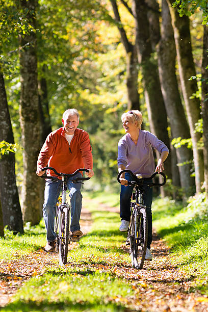 seniores exercitar com bicicleta - action mature adult bicycle senior couple imagens e fotografias de stock