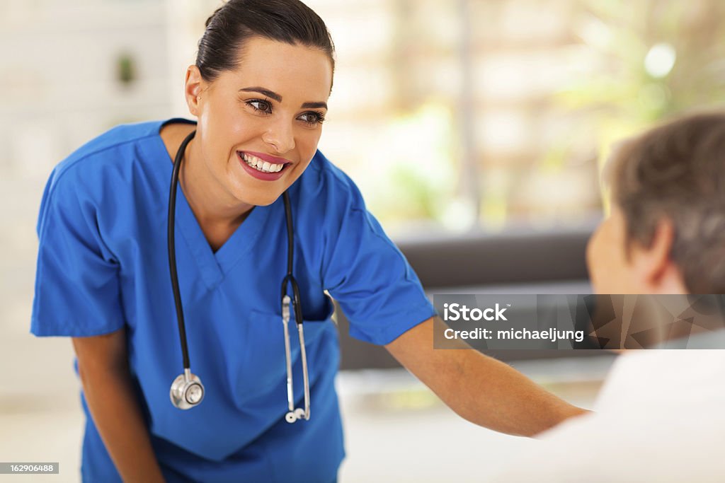 Simpática jovem enfermeira falar com paciente idoso - Royalty-free Profissional de enfermagem Foto de stock