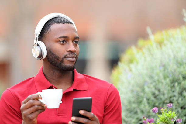 istock Black man listening to music and drinking 1629075628