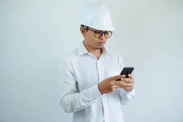 istock young asian male architect engineer serious while looking at the cellphone isolated on white background. 1629081460
