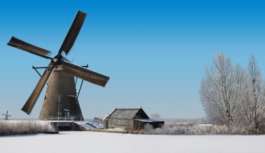 Typical dutch windmill and an old shack in the winter