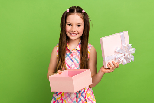 Photo of adorable lovely girl wear trendy clothes open gift celebrate festive event isolated on green color background.