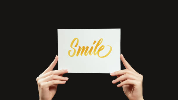 istock Smile sign positive motivation hands text placard 1629108188