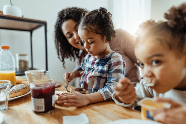 istock Afro Caribbean mother with two daughters eating breakfast 1629112552