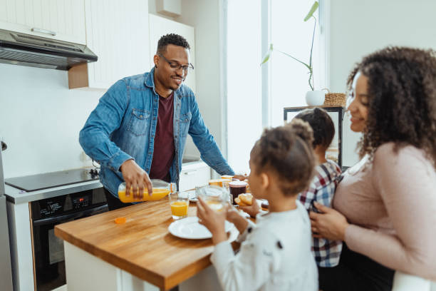 istock Afro Caribbean mother with two daughters eating breakfast and smiling 1629112559