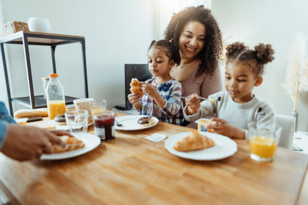 istock Afro Caribbean mother with two daughters eating breakfast 1629113180