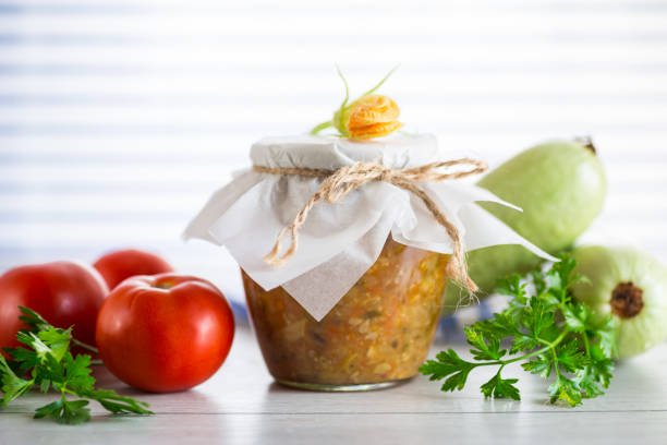 Cooked zucchini caviar with tomatoes in a glass jar,. stock photo