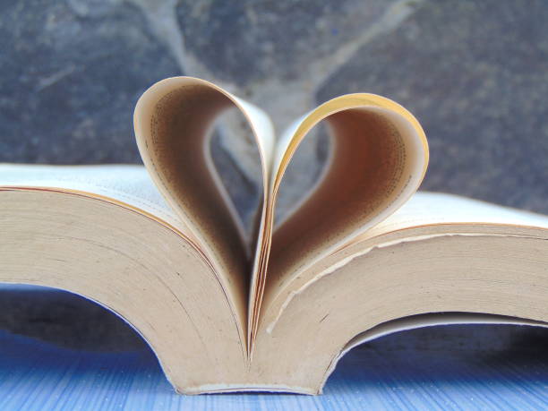 istock an open book with folded paper forming a love on the table. 1629122038