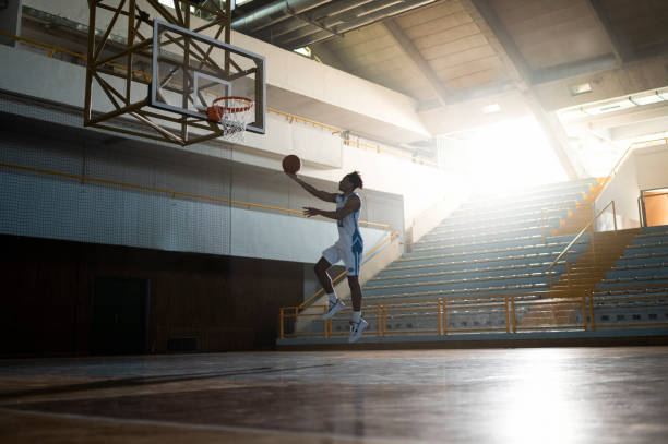 istock Man jumping mid-air with basketball 1629131211