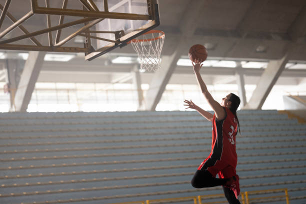 istock Woman throwing basketball towards basket 1629131222