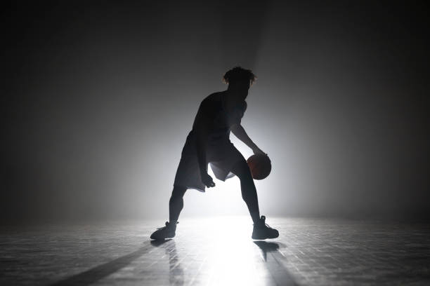 istock Young man dribbling basketball on court 1629131472