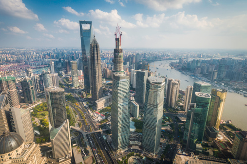 Dramatic high angle view across the futuristic skyscrapers and landmarks of Pudong, the Shanghai Stock Exchange, Shanghai World Financial Center, Jin Mao Tower and Lujiazui financial district banking towers on the banks of the Huangpu River, Shanghai, China. ProPhoto RGB profile for maximum color fidelity and gamut.