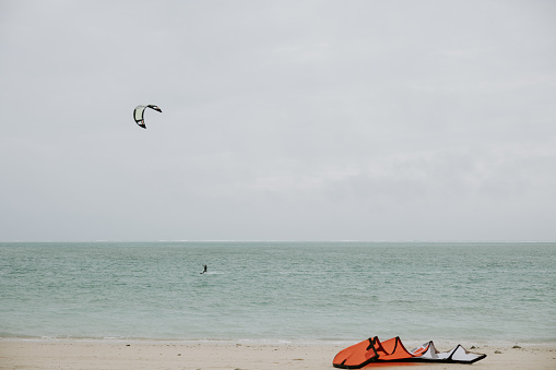 Woman jumping during kiteboard surfing at sea. Copy space.