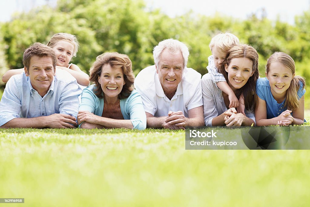 We've got a really close family bond Positive three generation family lying together on the grass outdoors - copyspace Adult Stock Photo