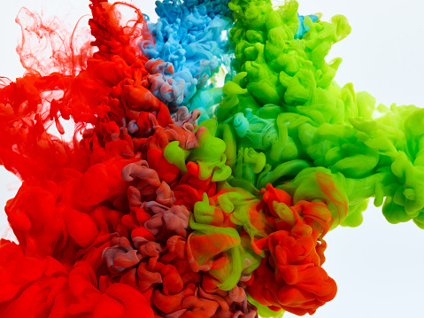 Splash of blue, red and green paints in water over white background