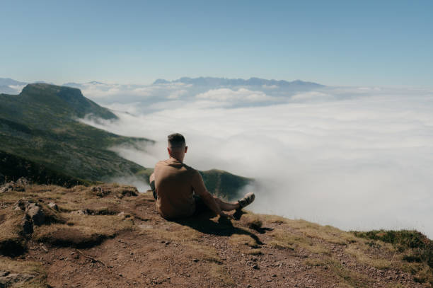 istock Man sitting on top of a mountain 1629180054