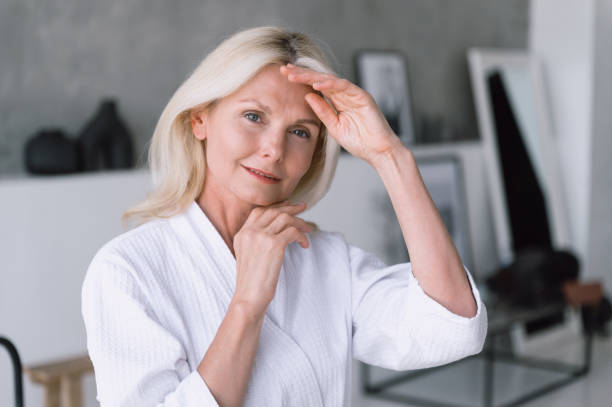 istock Smiling woman making lifting massage for mature skin 1629183971