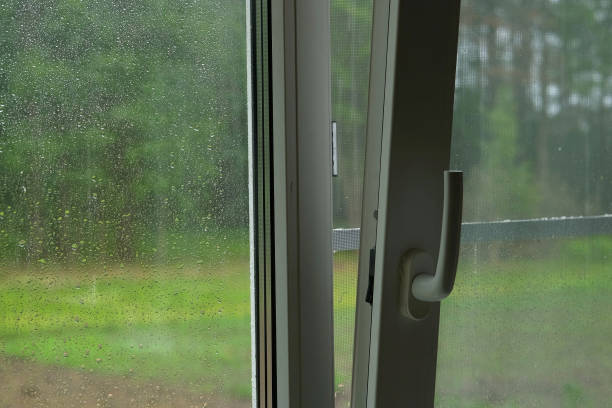 istock Raindrops on a window pane. Rain drops on transparent glass on a green background. Soft focus. Concept of sadness, bad mood, Wet. Gray sky. Rainy summer weather. Close Up view of droplet of water. 1629197873