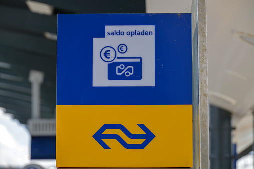 Sign at pole where travel balance can be recharged on train payment card,