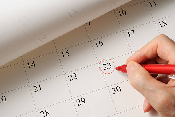 fijar la fecha en el calendario de pluma roja - fecha escrita fotografías e imágenes de stock