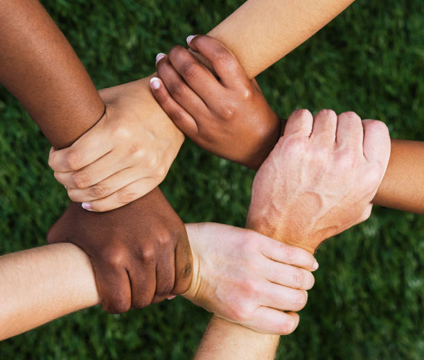 istock Diverse group of people with hands, wrists and arms interlinked, representing solidarity and teamwork 1629223686