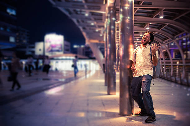 Man Playing Air Guitar Man playing air guitar in a modern train station at night. Location: Bangkok, Thailand. air guitar stock pictures, royalty-free photos & images