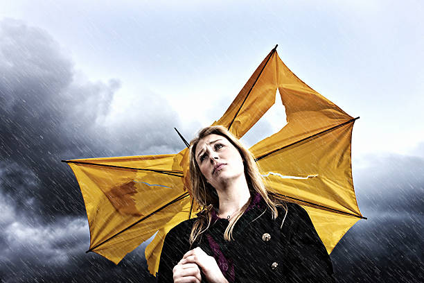 istock Unhappy young blonde with torn umbrella in thunderstorm 162923950