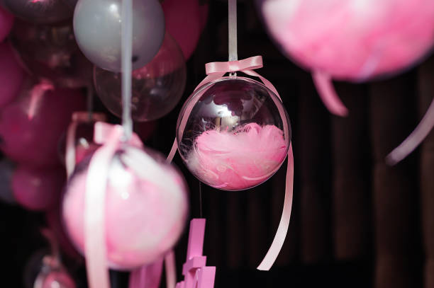 istock Transparent balloons with pink feathers inside hangs on the party 1629249299