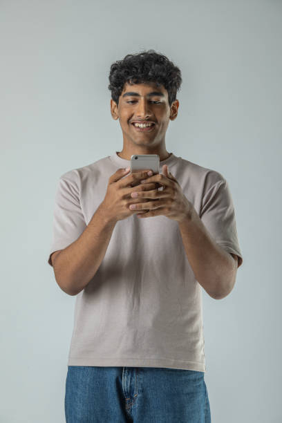 istock Teenage boy messaging over smart phone on white background 1629252119