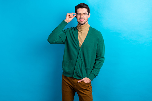Photo of charming cool guy dressed green cardigan arm eyewear smiling isolated blue color background.