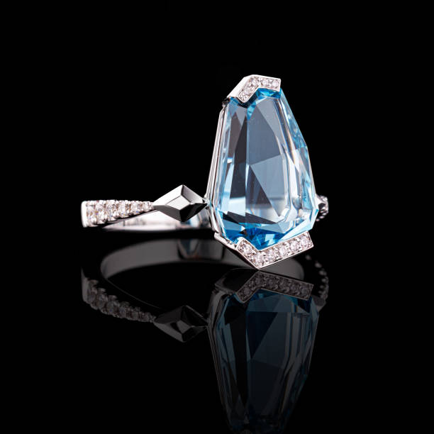 istock beautiful white gold ring with diamonds and aquamarine on a black background 1629255431
