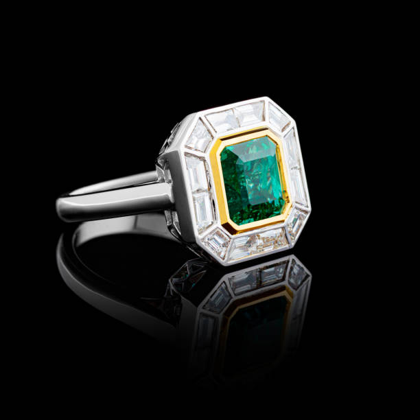 istock beautiful white gold ring with diamonds and emerald on a black background 1629255442
